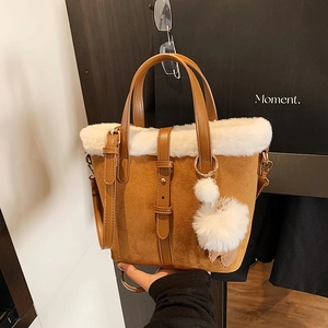 Brown suede bucket bag with white faux fur trim and gold metal hardware accents