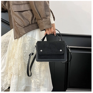 Close-up of stylish contrast handbag with suede flap and silver stud hardware details