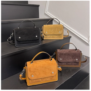 Close-up of contrast patchwork handbags in black, brown, khaki and ginger suede and leather
