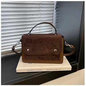 Detail of contrast stitch handbag with suede flap, silver rivets and metal hardware