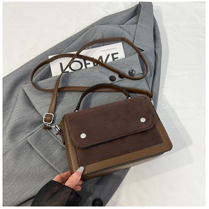 Detail of contrast stitch handbag with silver buckles and mixed leather textures