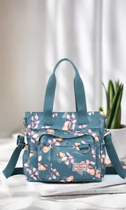 Dettaglio della borsa tote in nylon floreale con tasche anteriori e tracolla