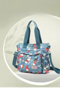 Dettaglio della borsa tote floreale in nylon con stampa fragola e tracolla regolabile