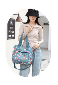 Dettaglio della borsa tote in nylon floreale con motivi a fragola e tracolla regolabile