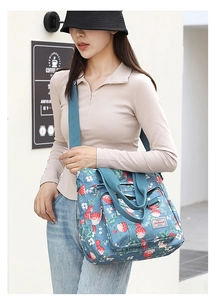 Dettaglio della borsa tote in nylon floreale con stampe di fragole blu e tasca frontale