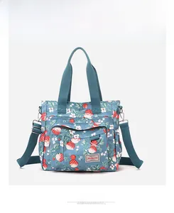 Dettaglio borsa shopper in tela blu con motivi a fragola e tracolla regolabile
