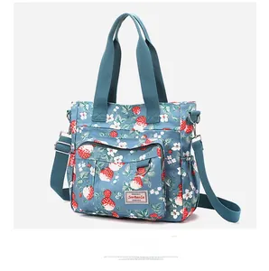 Dettaglio della borsa tote capiente in nylon con motivi floreali e fragole