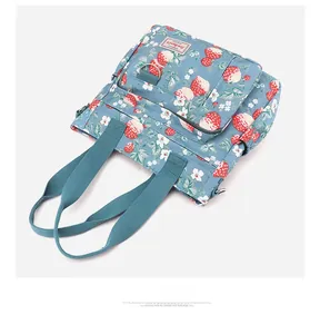 Dettaglio della borsa tote in nylon con motivo a fragole e tasche multifunzionali