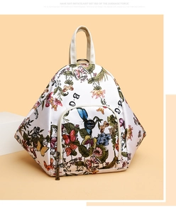 Detail of triangular backpack with colorful floral butterfly prints and sturdy top handle