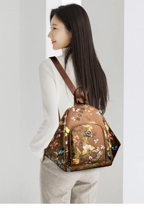 Close-up of a brown women's backpack with colorful butterfly and floral prints