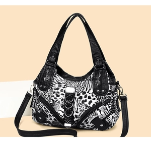 Detail of animal print handbag with leopard and zebra patterns and silver star charm