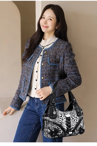 Detail of animal print handbag with silver hardware shown on a tweed jacket model