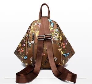 Detail of dark brown backpack featuring butterfly prints and adjustable fabric straps