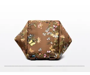 Detail of the printed brown bag bottom featuring butterfly patterns and adjustable D-rings