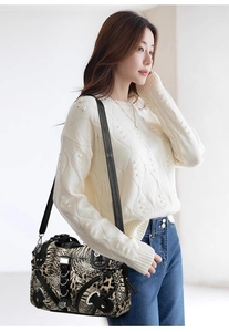 Close-up of leopard and tiger print crossbody bag with punk metal studs and rings