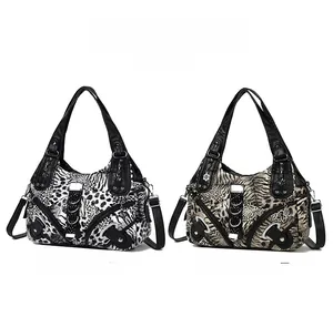 Detail of faux leather tote bags with animal prints, silver rivets, and metallic ring accents