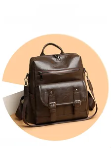 Detail of dark brown vintage faux leather backpack with metallic buckles and zipper pockets