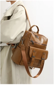 Caramel brown leather backpack featuring a double zipper main pocket and buckle detail