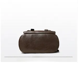 Detail view of the dark brown backpack bottom with high-quality pebbled leather texture