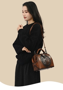Detail of vintage embossed leather handbag with floral patterns and a metallic clasp