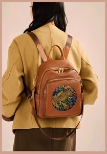 Detailed back view of a brown pebbled leather backpack featuring a colorful elephant emboss