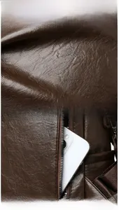 Detail of brown litchi pattern leather texture and anti-theft back zipper pocket on backpack