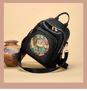 Detail of artistic elephant relief and textured lychee leather on a black backpack