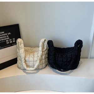 Détail de sacs à main matelassés en noir et beige avec une texture nuage douce