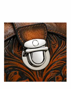 Detail of vintage embossed leather handbag featuring metallic snap buckle and floral patterns