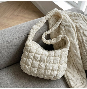 Détail de la texture matelassée à bulles et du tissu doux d'un sac bouffant crème