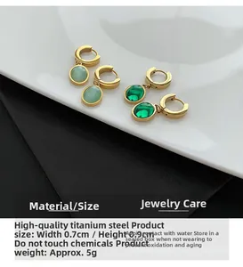 Détails macro des boucles d'oreilles en acier titane avec zircone émeraude de qualité