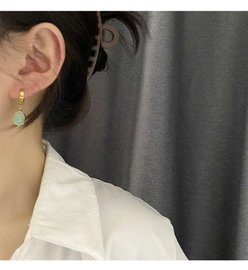 Vue détaillée des boucles d'oreilles goutte vert émeraude avec anneaux en métal doré