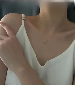 Gros plan d'un collier pendentif lapin doré avec zircons étincelants porté par un mannequin