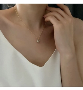 Détail macro d'un collier pendentif lapin doré avec sertissage de zircons blancs brillants