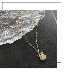 Détail d'un pendentif lapin doré avec micro-zircons pavés sur une chaîne en or fin