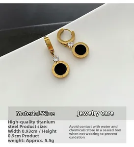 Détail de boucles d'oreilles en acier titane avec chiffres romains et zircon noir