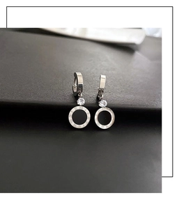 Macro des boucles d'oreilles en acier titane argent avec chiffres romains et zircon noir