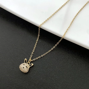 Collier avec pendentif lapin doré et zircons étincelants sur fond à contraste élevé