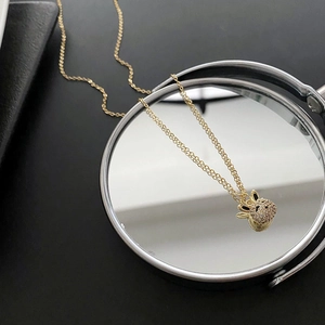 Collier pendentif lapin doré élégant avec pavé de cristaux sur surface noire réfléchissante