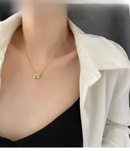 Gros plan d'un collier pendentif papillon doré avec cristaux sur le cou d'un mannequin