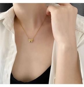 Gros plan sur le collier papillon doré serti de zircons avec une chaîne fine