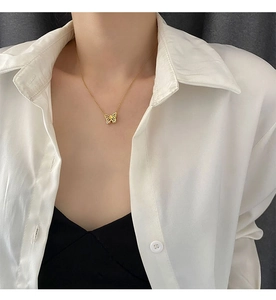 Gros plan d'un collier pendentif papillon doré avec détail en zircon sur un mannequin