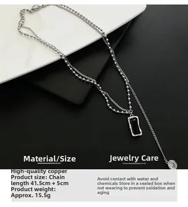 Close-up of double-layered silver chain necklace with a black rectangular pendant