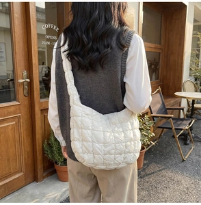 Vue détaillée d'un sac à main matelassé blanc porté dans un cadre de café