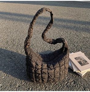 Détail d'un sac nuage matelassé marron foncé avec texture bouffante et bandoulière plissée
