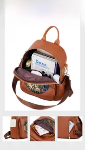 Detailed view of brown lychee leather backpack with ethnic patterns and multi-pocket interior