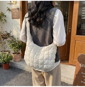 Photo en extérieur du sac bandoulière blanc matelassé avec motif à carreaux doux