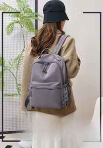 Detail of grey-purple nylon backpack featuring multi-layer storage and soft waterproof fabric