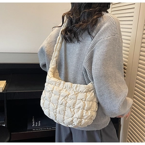 Vue latérale d'une femme portant un sac nuage matelassé blanc avec un tricot décontracté