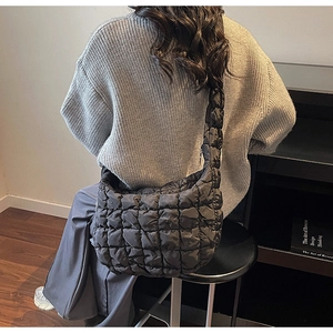Détail d'un sac bouffant noir matelassé montrant la texture et le tombé à l'épaule